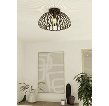 Plafondlamp met decoratieve metalen kap en gloeilamp in een modern ingerichte kamer.