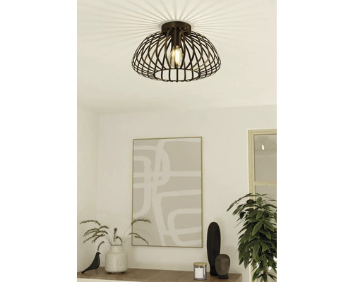 Plafondlamp met decoratieve metalen kap en gloeilamp in een modern ingerichte kamer.