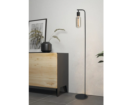 Staande lamp met retro gloeilamp naast een dressoir