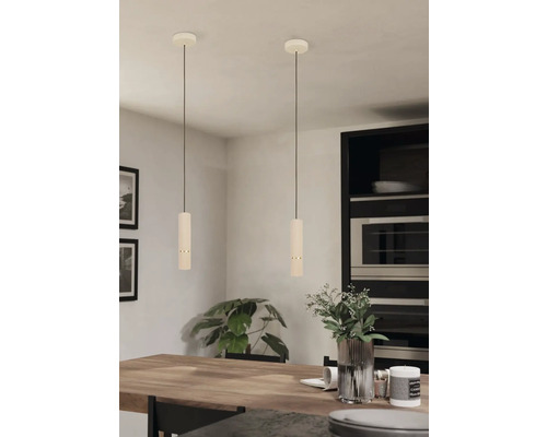 Twee hanglampen boven een houten tafel in een lichte kamer.