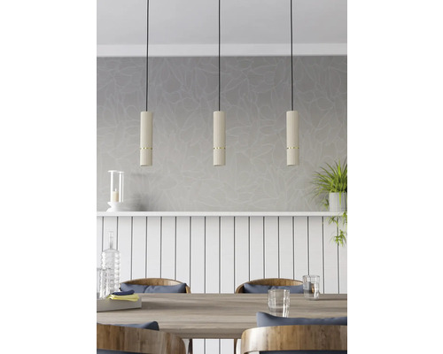 Drie hanglampen van geribbeld materiaal met gouden accenten boven een eettafel