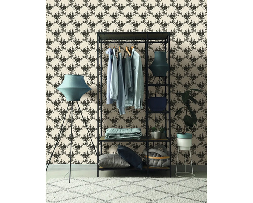 Inrichtingsvoorbeeld met kledingrek, vloerlamp en behang met motief voor een stijlvolle sfeer.