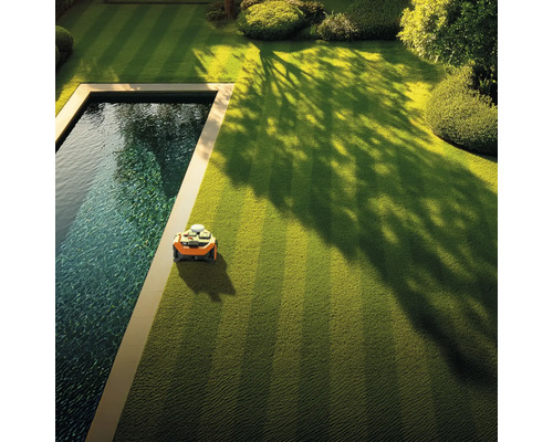 Robotmaaier op een gazon naast een zwembad