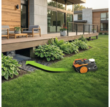Robotmaaier rijdt met groene pijl naar laadstation onder een houten terras