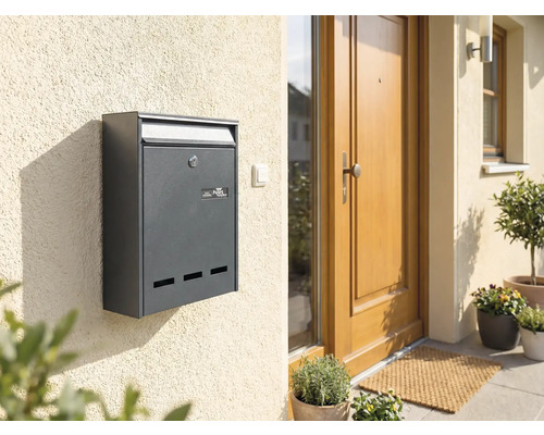 Antracietkleurige brievenbus aan een huismuur naast een voordeur