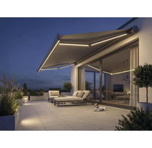 Terras met zonnescherm, tuinmeubelen en verlichting in de avond