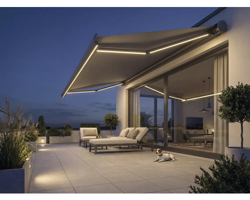 Terras met zonnescherm, tuinmeubelen en verlichting in de avond