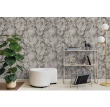 Moderne woonkamer met grijs-wit marmerbehang, groene kamerplant, witte poef, metalen stellingkast en een vloerlamp.