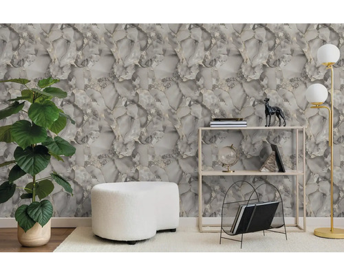 Moderne woonkamer met grijs-wit marmerbehang, groene kamerplant, witte poef, metalen stellingkast en een vloerlamp.