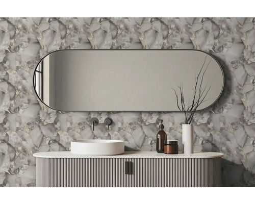 Vliesbehang met steenlook in een moderne badkamer met een ovale spiegel, witte opzetwastafel en geribbeld wastafelmeubel.