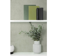 Gestructureerd vliesbehang in modern ingerichte kamer met wandplanken, boeken en vaas met eucalyptustakken.