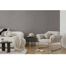 Moderne woonkamer met grijze vliestapet met structuur, witte gestoffeerde meubels, een glazen tafel en visgraatparket.