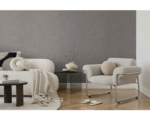 Moderne woonkamer met grijze vliestapet met structuur, witte gestoffeerde meubels, een glazen tafel en visgraatparket.