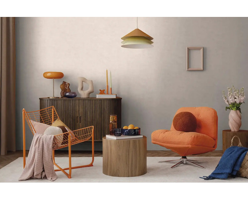 Moderne woonkamer met oranje fauteuil, oranje draadstoel, donkerhouten dressoir, ronde houten tafels en een hanglamp.