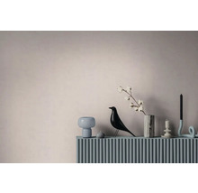 Moderne interieurdecoratie met een vogelbeeldje, een marmeren vaas met een katoentak en kandelaars op een geribbeld oppervlak.