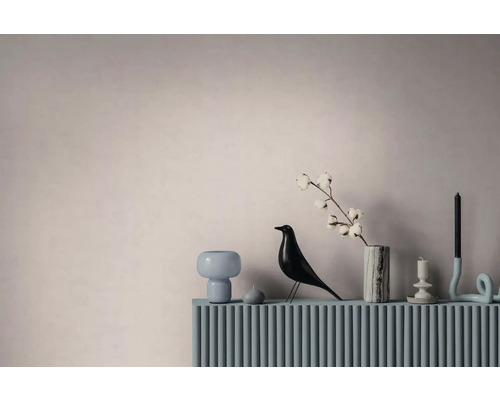 Moderne interieurdecoratie met een vogelbeeldje, een marmeren vaas met een katoentak en kandelaars op een geribbeld oppervlak.