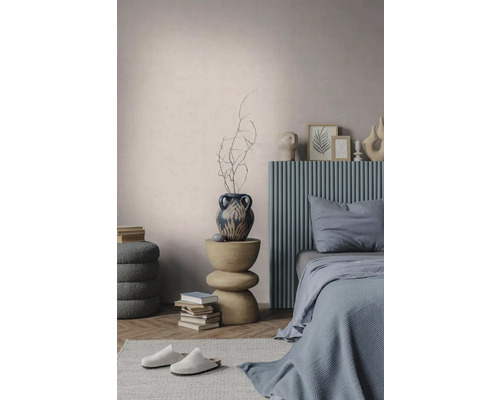 Moderne slaapkamer met een blauw geribbeld hoofdbord, een sculpturale houten bijzettafel, een decoratieve vaas en gestructureerde muren.