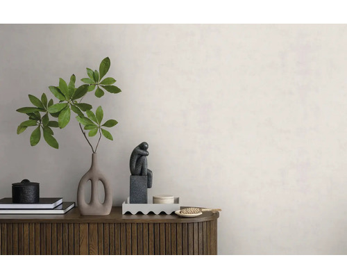 Moderne wanddecoratie met lichte muurverf, een houten dressoir, een vaas met een groene tak en decoratieve objecten.