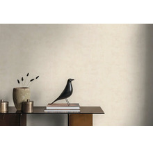 Lichte wand met gestructureerd behang in een minimalistische kamer met dressoir, decoratieve vogelfiguur en een stenen vaas.