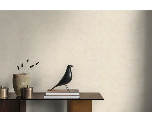 Lichte wand met gestructureerd behang in een minimalistische kamer met dressoir, decoratieve vogelfiguur en een stenen vaas.