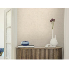 Gestructureerd beige behang op een muur achter een houten dressoir met decoratie. Lichte, georganiseerde sfeer.