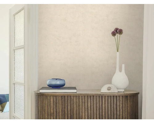 Gestructureerd beige behang op een muur achter een houten dressoir met decoratie. Lichte, georganiseerde sfeer.