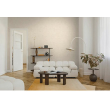 Licht ingerichte woonkamer met een witte gestoffeerde bank, een donkere houten salontafel, een booglamp en een visgraatparketvloer.