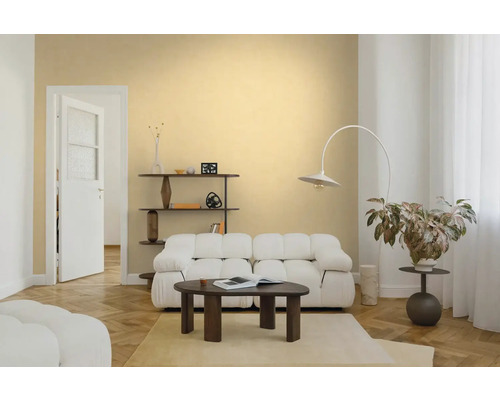 Lichte woonkamer met beige muurverf, witte bank, donkerhouten salontafel, booglamp en visgraatparket.