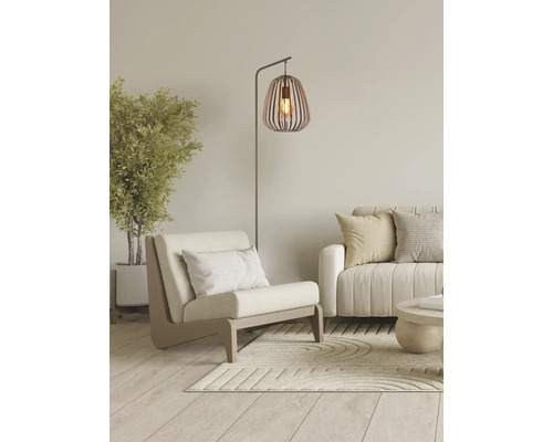 Woonkamer met fauteuil, staande lamp en bank voor een lichte en georganiseerde sfeer.