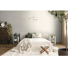 Lichte, georganiseerde slaapkamer met bed, witte hanglamp, houten meubels en kamerplanten. Gebruik van natuurlijk textiel en hout.