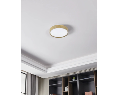 Plafondlamp met houten rand in een heldere, moderne kamer