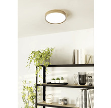 Plafondlamp met houten rand in een lichte ruimte boven een plank.