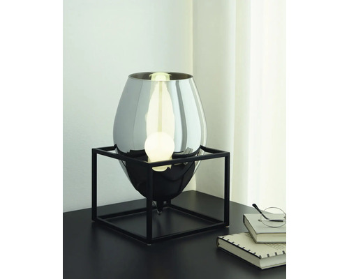 Decoratieve tafellamp met metalen voet en lamp op een tafel