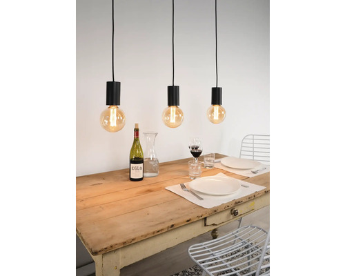 Scene met drie hanglampen boven een eettafel met servies en drankjes