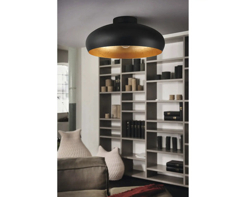 Zwarte plafondlamp met goudkleurige binnenkant in een woonkamer