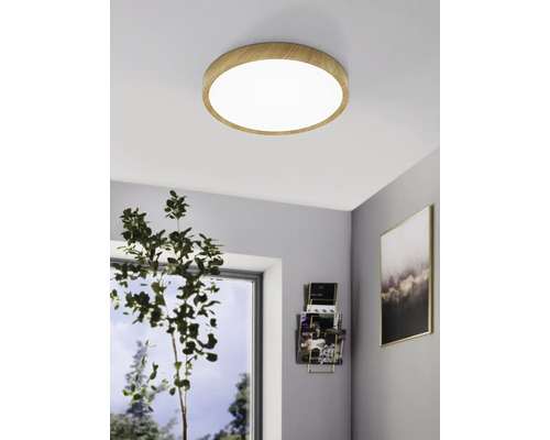 Ronde plafondlamp met houten frame aan het plafond