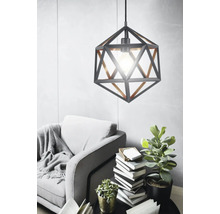 Metalen hanglamp met geometrisch ontwerp boven een fauteuil en een bijzettafel in de woonkamer.