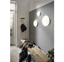 Lichte entree met houten kruk, wandlampen en kapstok