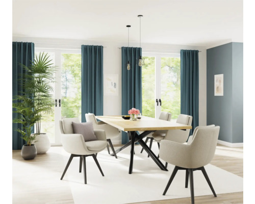 Lichte eetkamer met houten tafel, stoelen en kamerplanten voor ramen met gordijnen