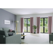 Woonkamer met bank, vloerlamp, tafel en gordijnen voor ramen