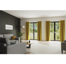 Woonkamer met grijze banken, staande lamp en gordijnen voor openslaande deuren