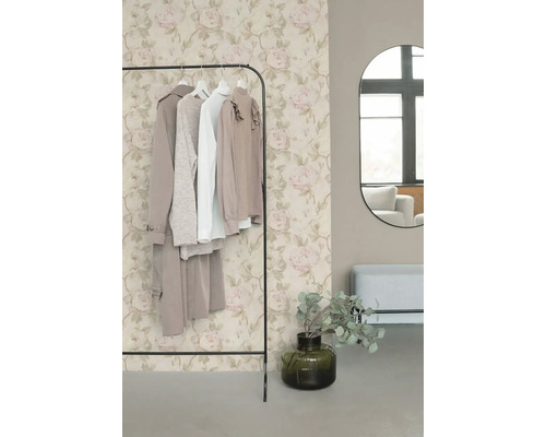 Vliesbehang met romantisch rozenpatroon in beige en roze achter een kledingrek in een modern ingerichte kleedkamer.