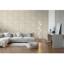 Vliesbehang met licht rozenpatroon in een modern ingerichte woonkamer met bank, visgraatparket en vloerlamp.