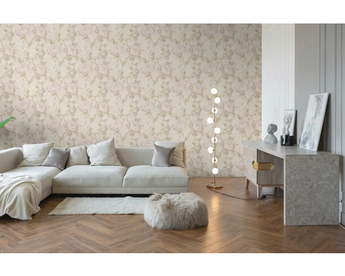 Vliesbehang met licht rozenpatroon in een modern ingerichte woonkamer met bank, visgraatparket en vloerlamp.