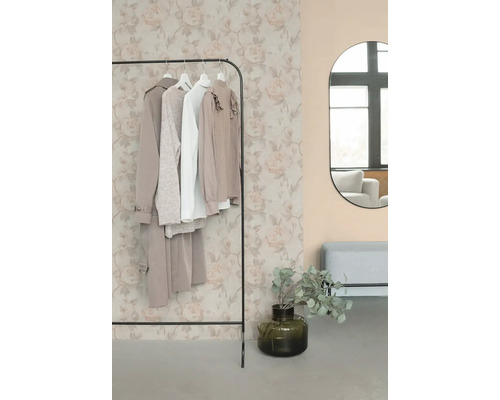 Vliesbehang met bloemenpatroon van rozen in lichte tinten in een modern ingerichte kamer met kledingrek en spiegel.