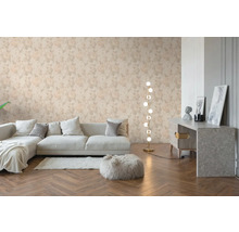 Woonkamer met bloemenbehang met rozenpatroon, lichte bank, houten visgraatvloer en een moderne vloerlamp.