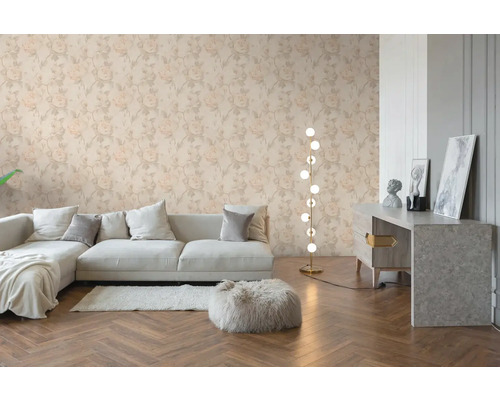 Woonkamer met bloemenbehang met rozenpatroon, lichte bank, houten visgraatvloer en een moderne vloerlamp.