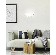 Woonkamer met bank, wandlamp en decoratieve objecten voor een gezellige sfeer