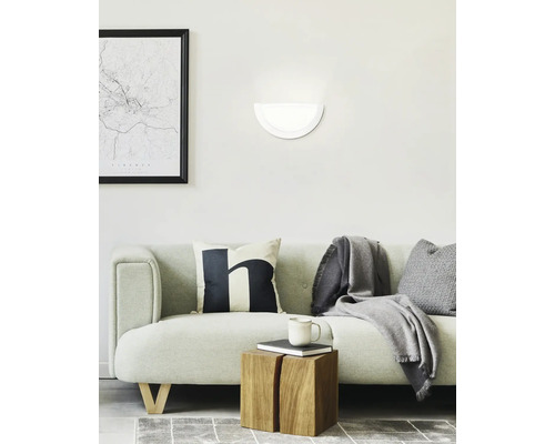 Woonkamer met bank, wandlamp en decoratieve objecten voor een gezellige sfeer