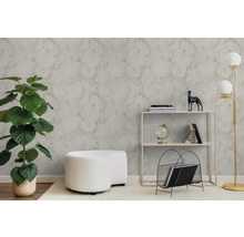 Moderne woonkamer met getextureerd behang met marmerlook, een grote groene plant, een witte hocker en een minimalistische stellingkast.